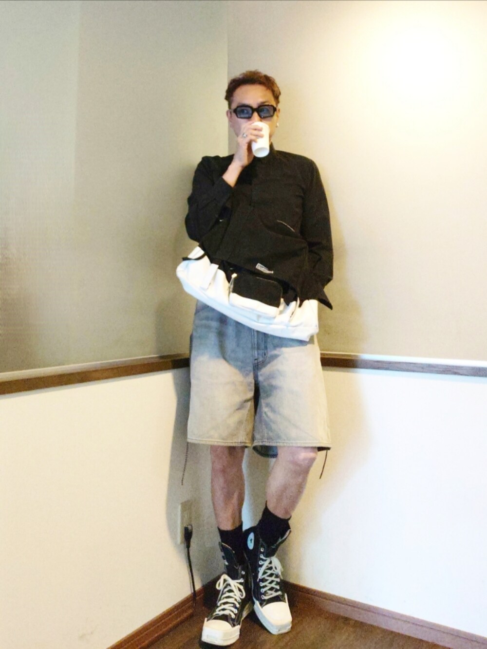 グレー系のパンツ、ホワイト系のショルダーバッグ、ブラック系のスニーカーを着用したメンズの夏コーディネートの3枚目の写真