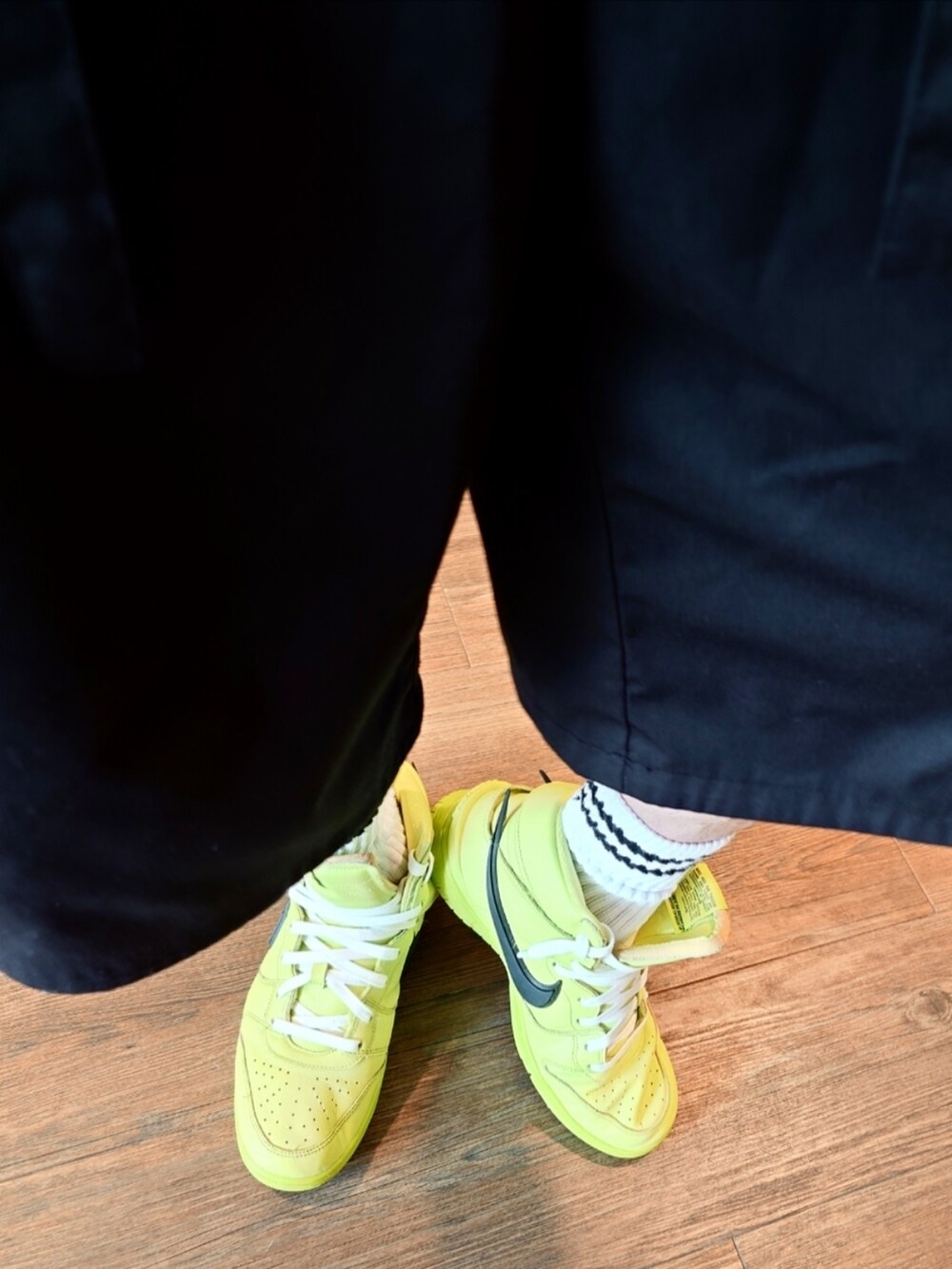 グリーン系のスニーカー、ブラック系のカーゴパンツ、ブラック系のTシャツ/カットソーを着用したメンズの夏コーディネートの2枚目の写真