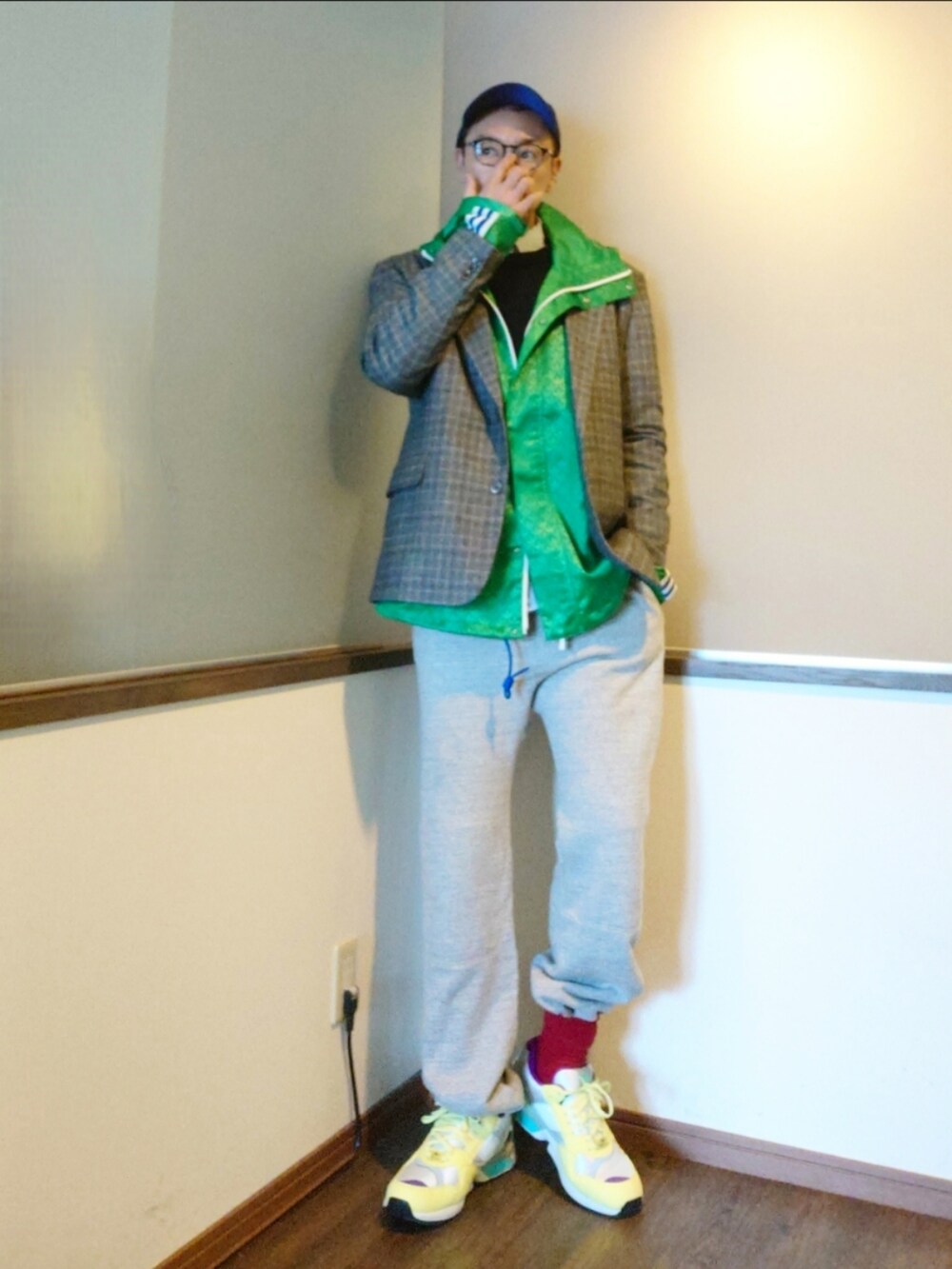 グレー系のスウェットパンツ、グレー系のテーラードジャケット、グリーン系のナイロンジャケットを着用したメンズの春コーディネートの2枚目の写真