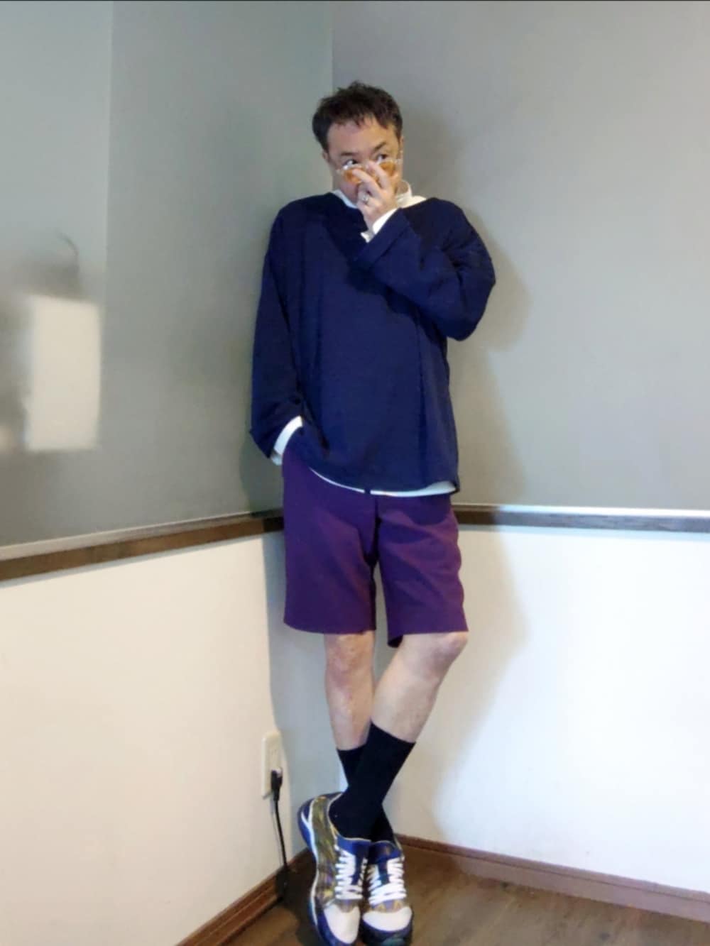 パープル系のスラックス、ブルー系のニット/セーター、ブルー系のスニーカーを着用したメンズの夏コーディネートの3枚目の写真