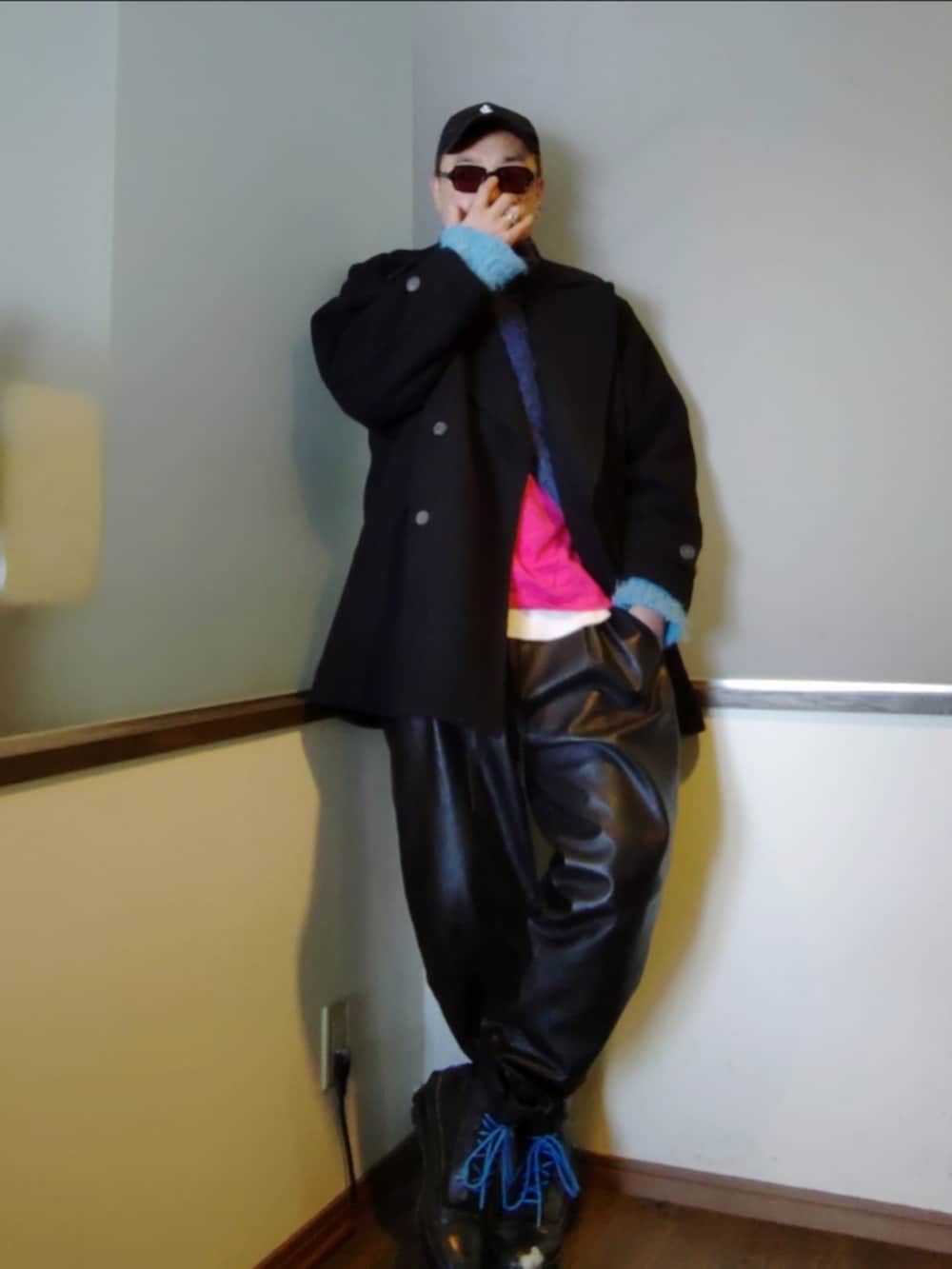 ブラック系のピーコート、ピンク系のTシャツ/カットソー、ブルー系のニット/セーターを着用したメンズの冬コーディネートの2枚目の写真