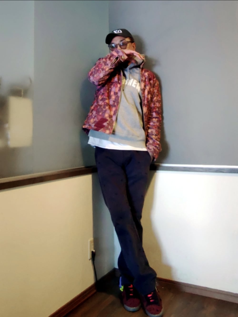 ピンク系のブルゾン、グレー系のパーカー、ブルー系のチノパンツを着用したメンズの春コーディネートの2枚目の写真