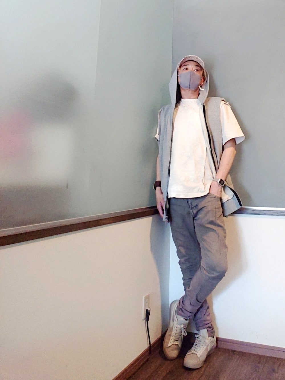 グレー系のベスト、ホワイト系のTシャツ/カットソー、ブラウン系のデニムパンツを着用したメンズの夏コーディネートの2枚目の写真