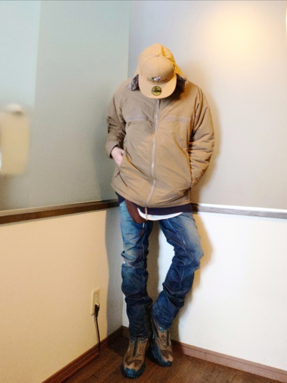 ベージュ系のダウンジャケット/コート、ブルー系のニット/セーター、ブルー系のデニムパンツを着用したメンズの冬コーディネートの3枚目の写真