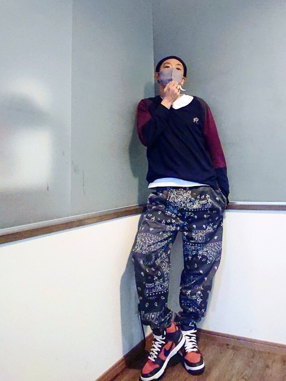 ブルー系のニット/セーター、ブラック系のテーラードジャケット、レッド系のスニーカーを着用したメンズの春コーディネートの2枚目の写真