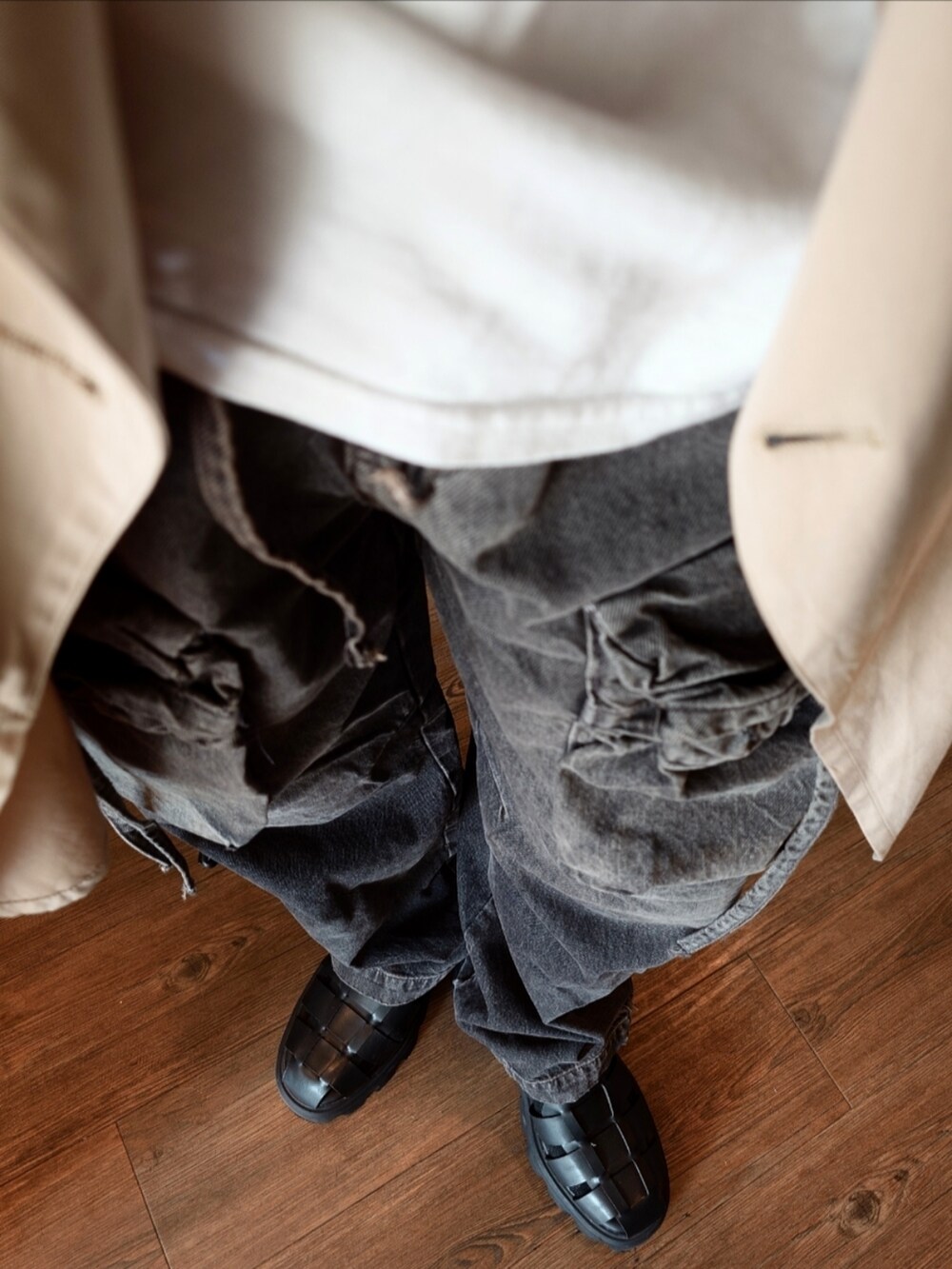 ベージュ系のトレンチコート、ホワイト系のTシャツ/カットソー、ブラック系のカーゴパンツを着用したメンズの夏コーディネートの3枚目の写真