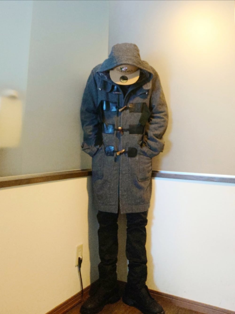 グレー系のダッフルコート、ブラウン系のニット/セーター、ブラック系のパンツを着用したメンズの冬コーディネートの3枚目の写真