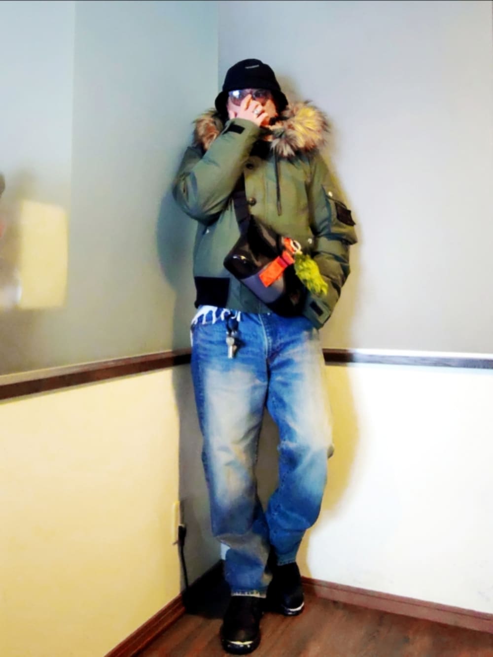 グリーン系のミリタリージャケット、ブルー系のデニムジャケット、ブルー系のデニムパンツを着用したメンズの冬コーディネートの2枚目の写真