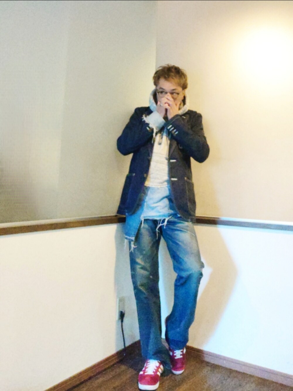 グレー系のパーカー、ブルー系のテーラードジャケット、ブルー系のデニムパンツを着用したメンズの秋コーディネートの3枚目の写真