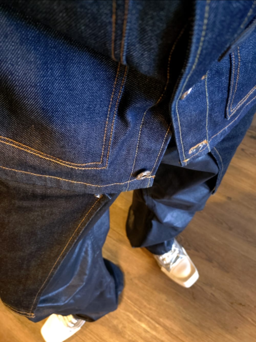 ブルー系のデニムジャケット、ブルー系のデニムパンツ、シルバー系のスニーカーを着用したメンズの秋コーディネートの5枚目の写真