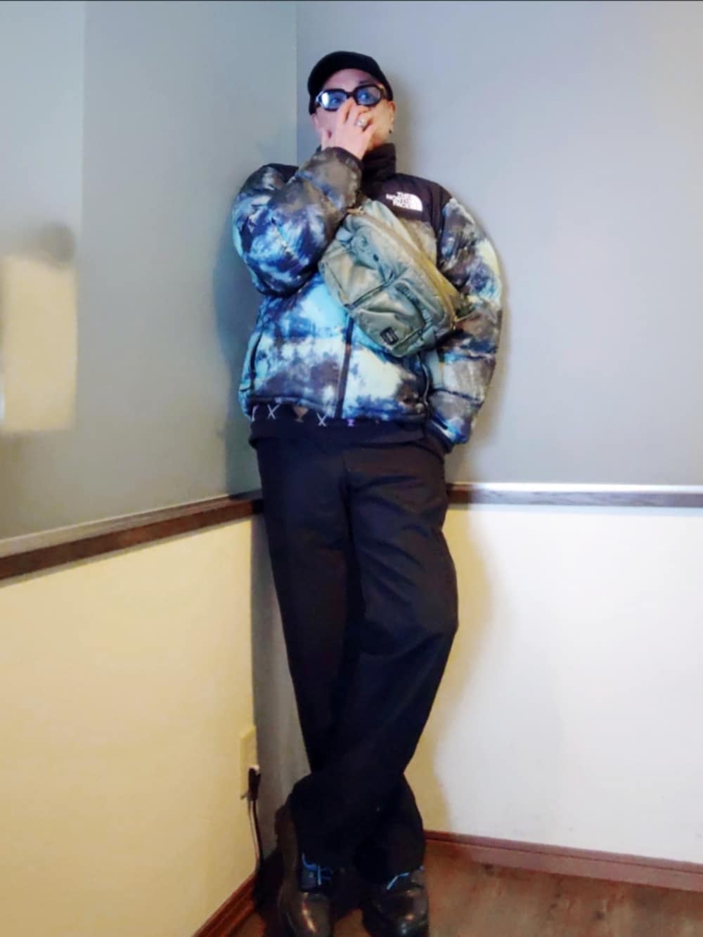 ブルー系のダウンジャケット/コート、ブラック系のポロシャツ、グリーン系のボディバッグ/ウエストポーチを着用したメンズの冬コーディネートの2枚目の写真