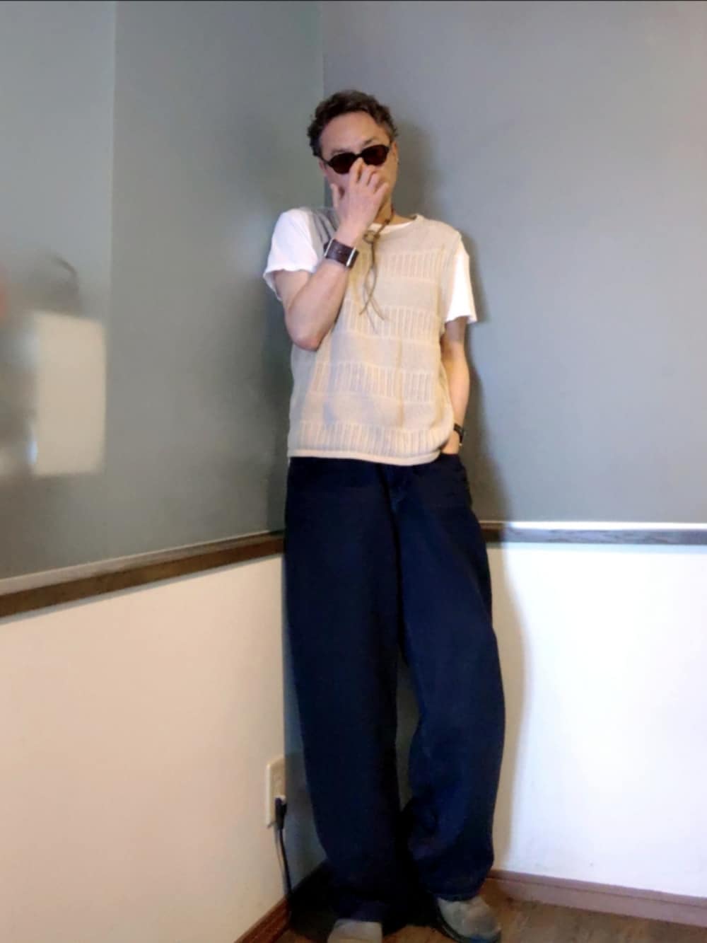 ブラック系のデニムパンツ、グリーン系のブーツ、ブラウン系のベストを着用したメンズの夏コーディネートの2枚目の写真