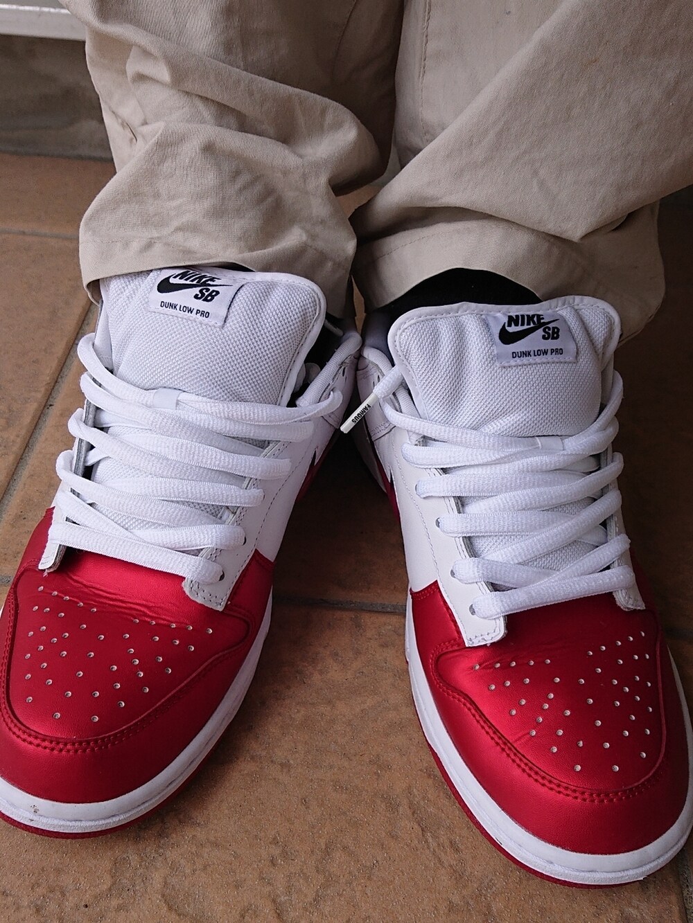 ブルー系のニット/セーター、ホワイト系のTシャツ/カットソー、ベージュ系のチノパンツを着用したメンズの夏コーディネートの3枚目の写真