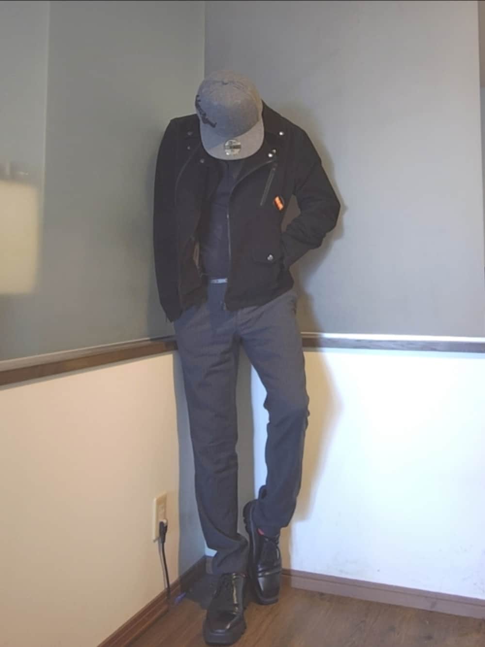 ブラック系のライダースジャケット、グレー系のスラックス、ブラック系のドレスシューズを着用したメンズの秋コーディネートの2枚目の写真