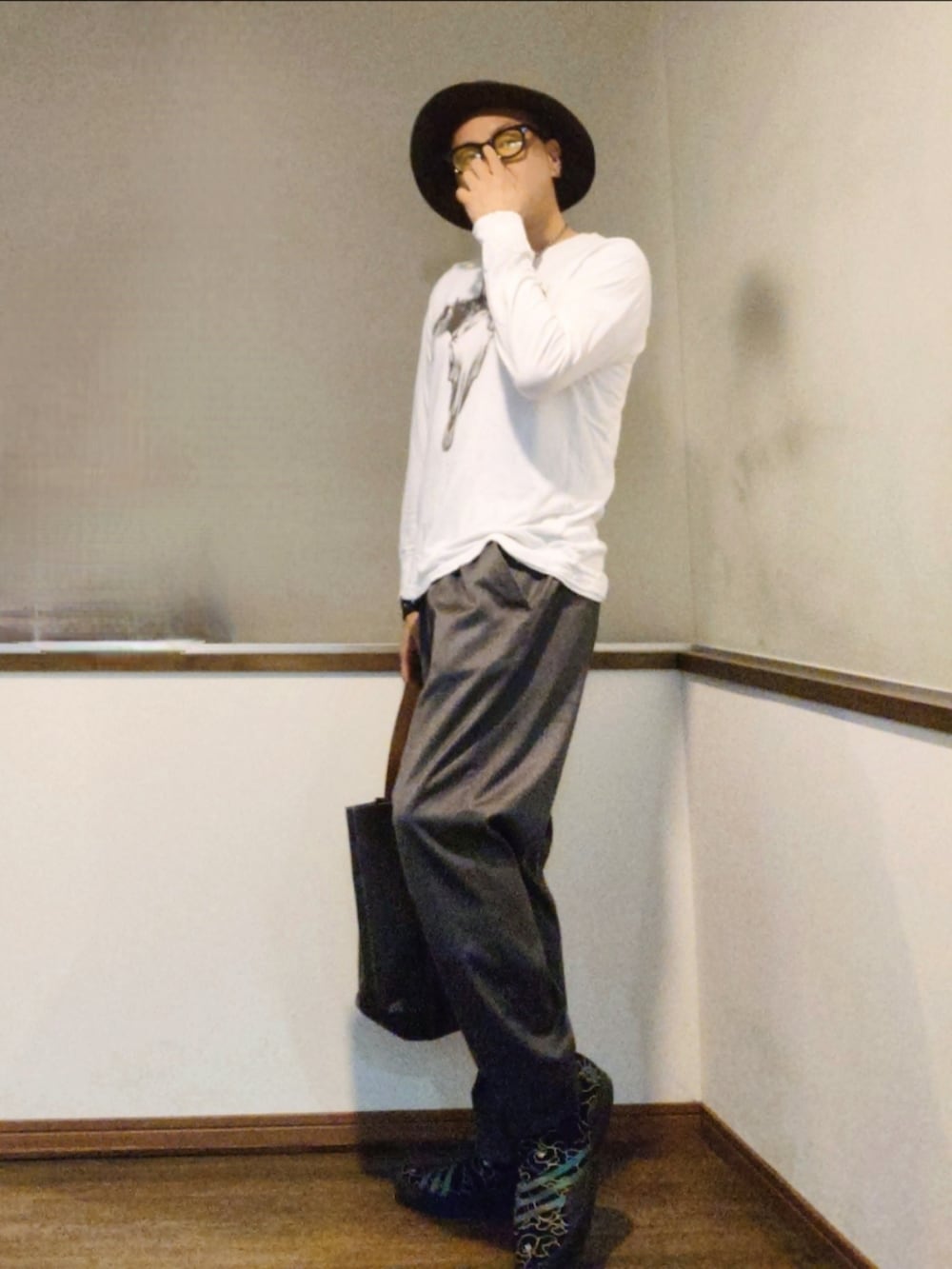 ホワイト系のTシャツ/カットソー、ブルー系のトートバッグ、グレー系のスラックスを着用したメンズの夏コーディネートの2枚目の写真