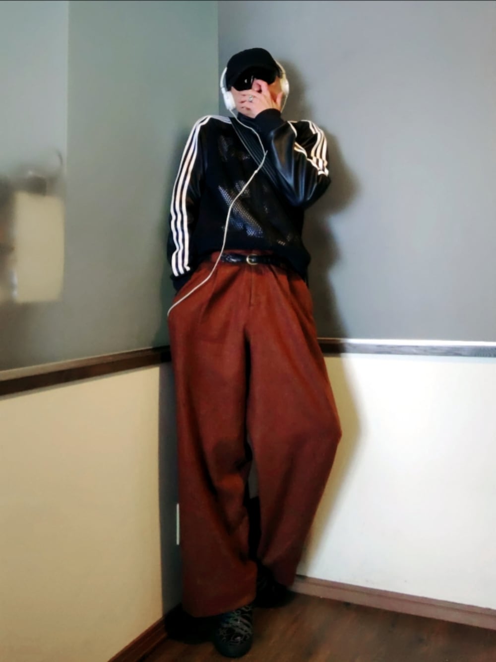 ブラック系のジャージ、ブラウン系のパンツ、ブラック系のニット/セーターを着用したメンズの春コーディネートの2枚目の写真