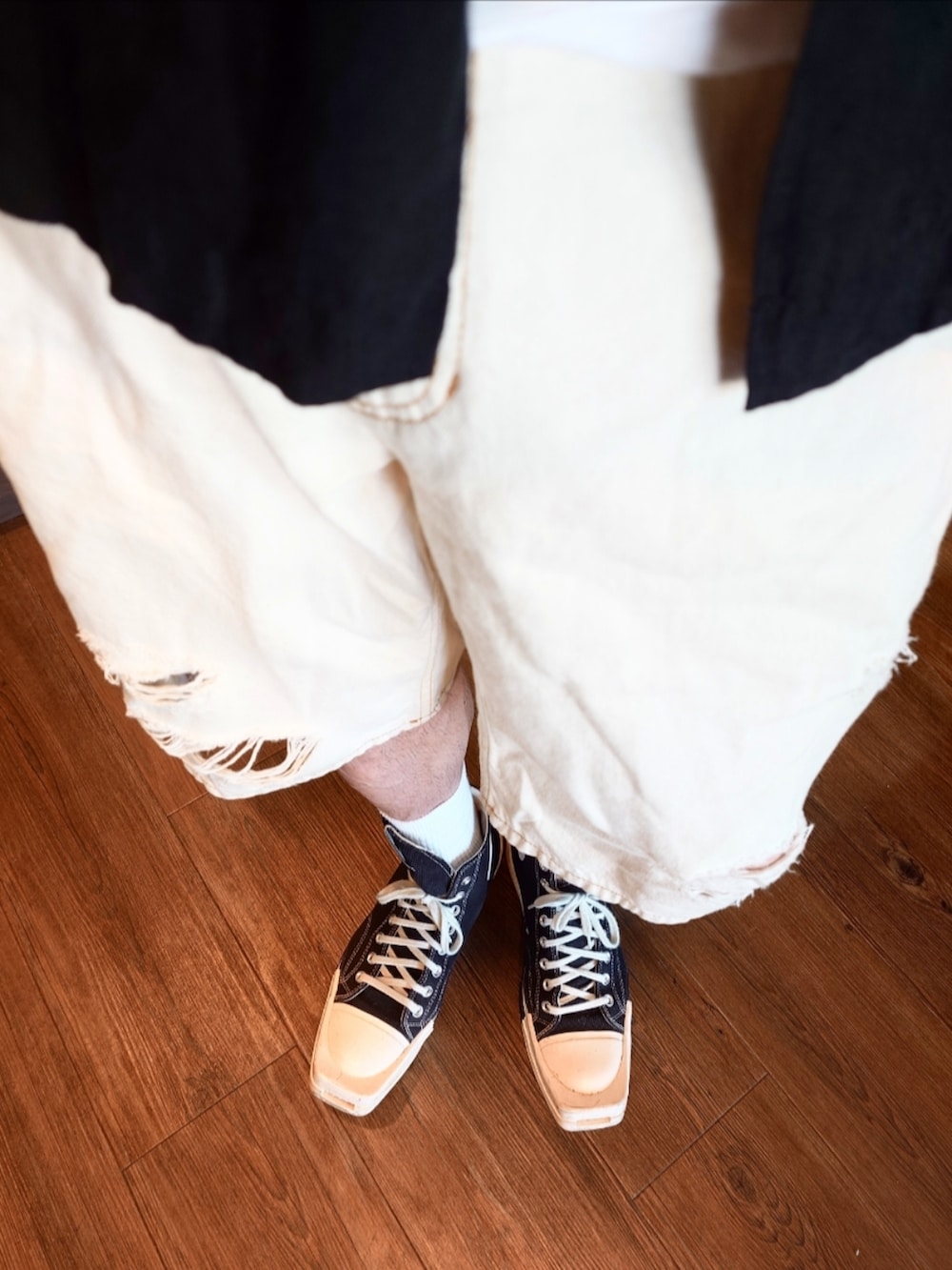ホワイト系のデニムパンツ、ホワイト系のショルダーバッグ、ブラック系のスニーカーを着用したメンズの夏コーディネートの3枚目の写真