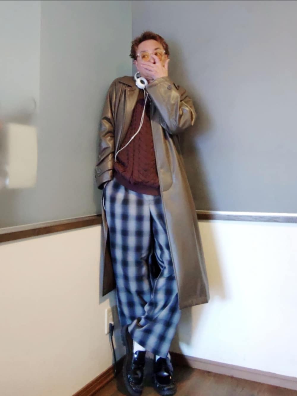 パープル系のニット/セーター、グリーン系のステンカラーコート、ブラック系のローファーを着用したメンズの春コーディネートの2枚目の写真