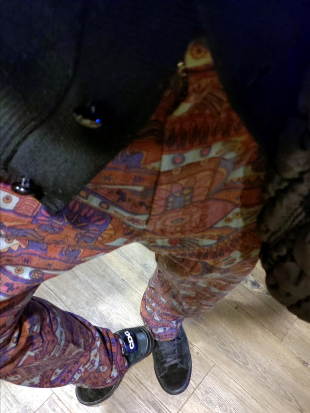 ブラック系のカーディガン/ボレロ、レッド系のパンツ、ブラック系のスニーカーを着用したメンズの秋コーディネートの4枚目の写真