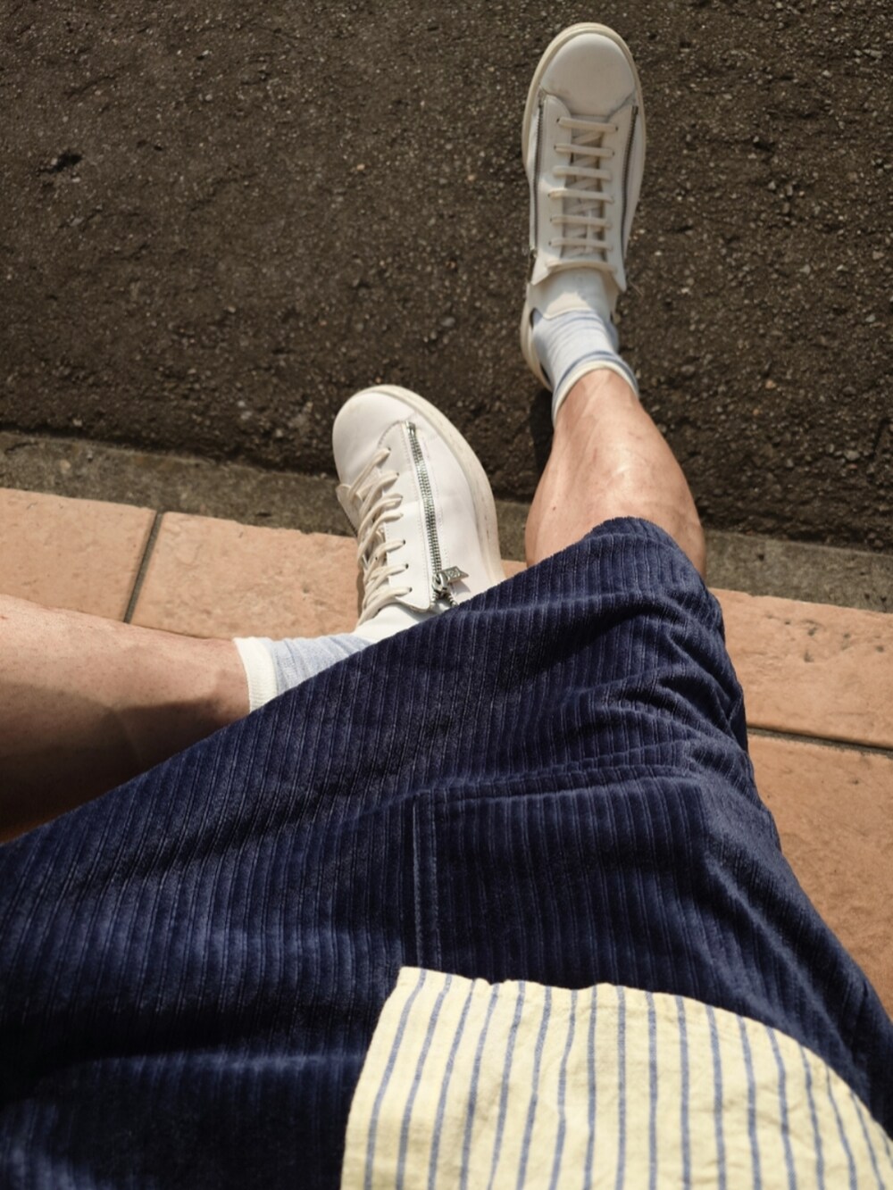 イエロー系のシャツ/ブラウス、ブルー系のその他パンツ、ホワイト系のスニーカーを着用したメンズの夏コーディネートの3枚目の写真