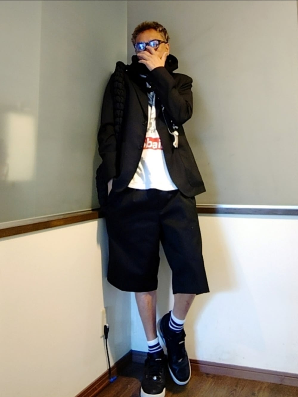 グレー系のテーラードジャケット、ホワイト系のTシャツ/カットソー、ブラック系のチノパンツを着用したメンズの秋コーディネートの2枚目の写真