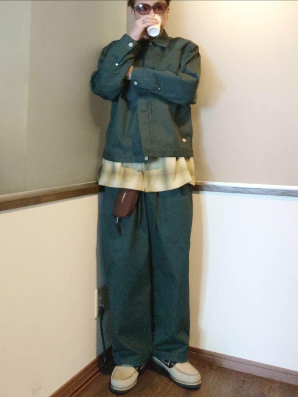 グリーン系のブルゾン、グリーン系のシャツ/ブラウス、ブラウン系のバッグを着用したメンズの春コーディネートの2枚目の写真