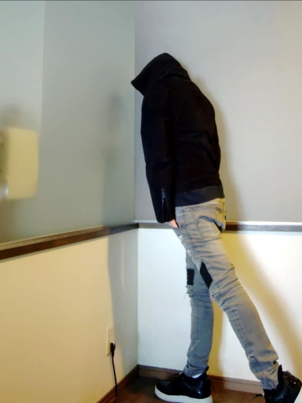 グレー系のデニムパンツ、ブラック系のライダースジャケット、ブラック系のスニーカーを着用したメンズの冬コーディネートの4枚目の写真