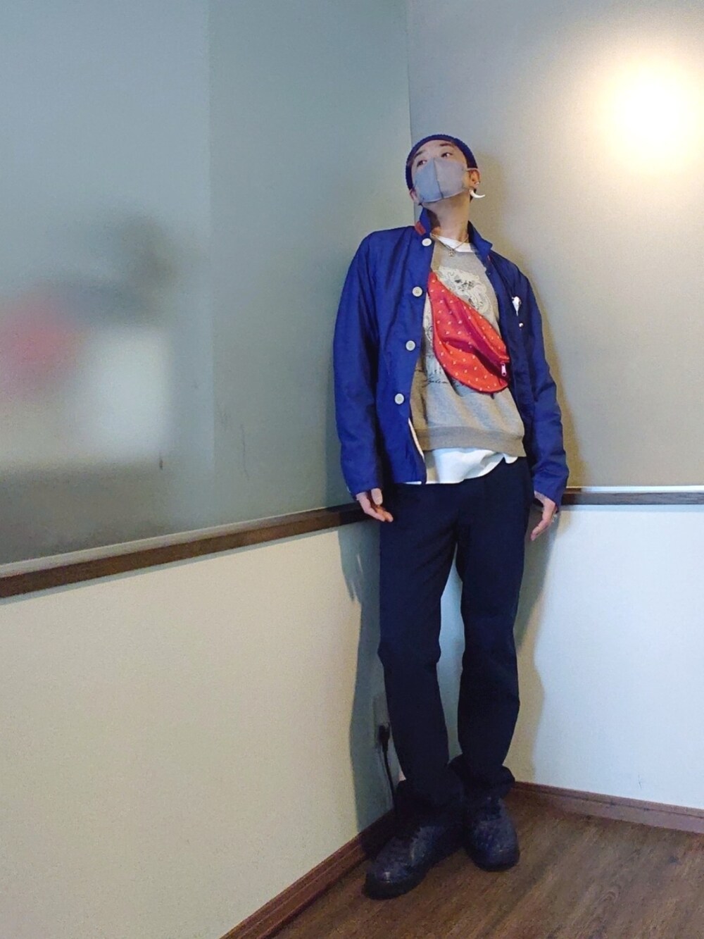 ブルー系のカバーオール、グレー系のスウェット、レッド系のショルダーバッグを着用したメンズの春コーディネートの3枚目の写真