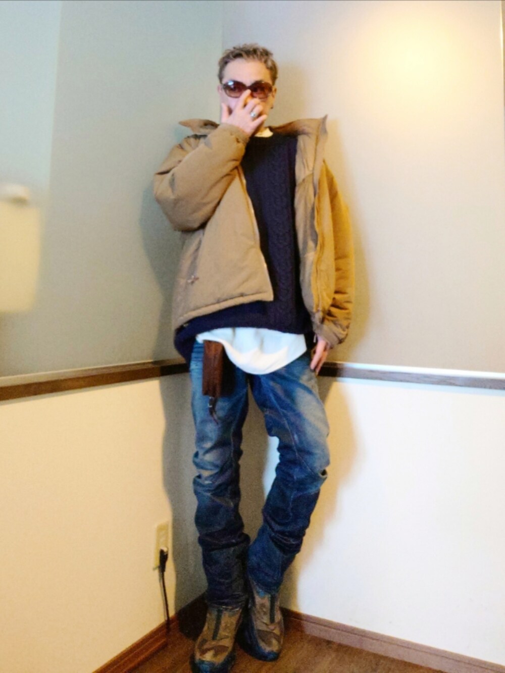 ベージュ系のダウンジャケット/コート、ブルー系のニット/セーター、ブルー系のデニムパンツを着用したメンズの冬コーディネートの4枚目の写真