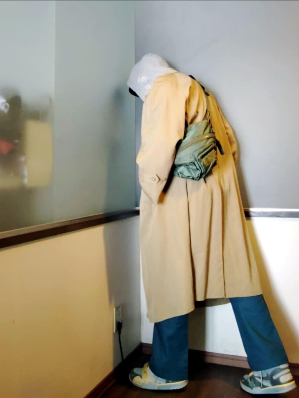 ベージュ系のトレンチコート、グリーン系のボディバッグ/ウエストポーチ、グリーン系のチノパンツを着用したメンズの春コーディネートの4枚目の写真