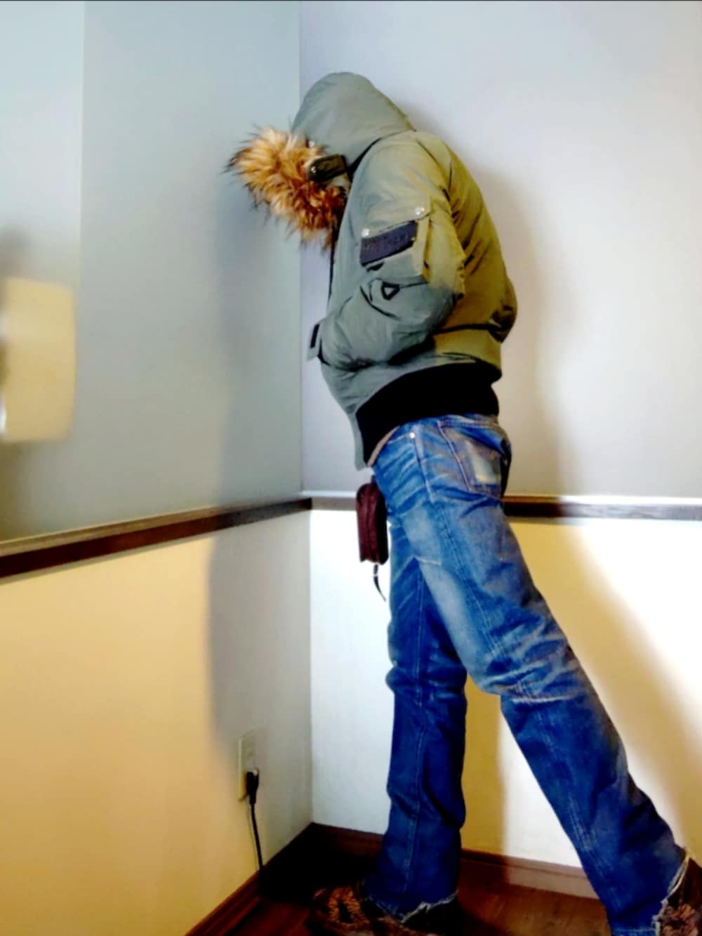 グリーン系のミリタリージャケット、ブルー系のデニムパンツ、ブラウン系のブーツを着用したメンズの冬コーディネートの3枚目の写真