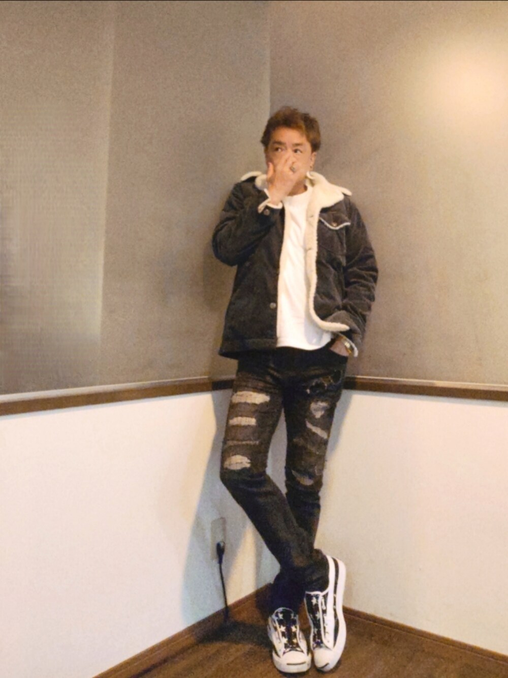 グレー系のブルゾン、ブラック系のデニムパンツ、ホワイト系のスニーカーを着用したメンズの秋コーディネートの4枚目の写真