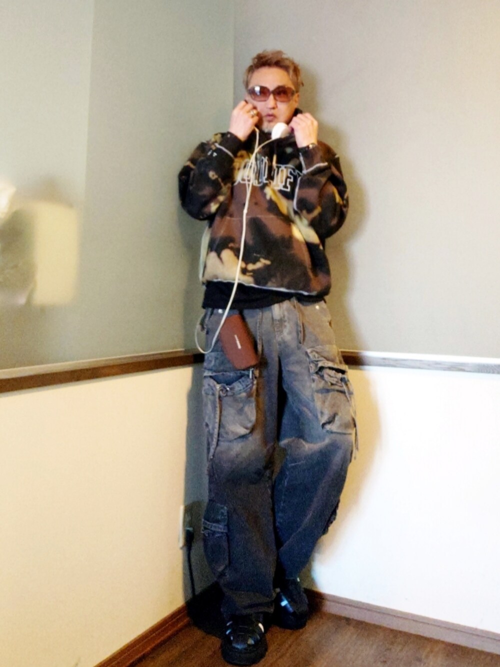 ブラック系のパーカー、ブラック系のカーゴパンツ、ブラック系のサンダルを着用したメンズの春コーディネートの2枚目の写真