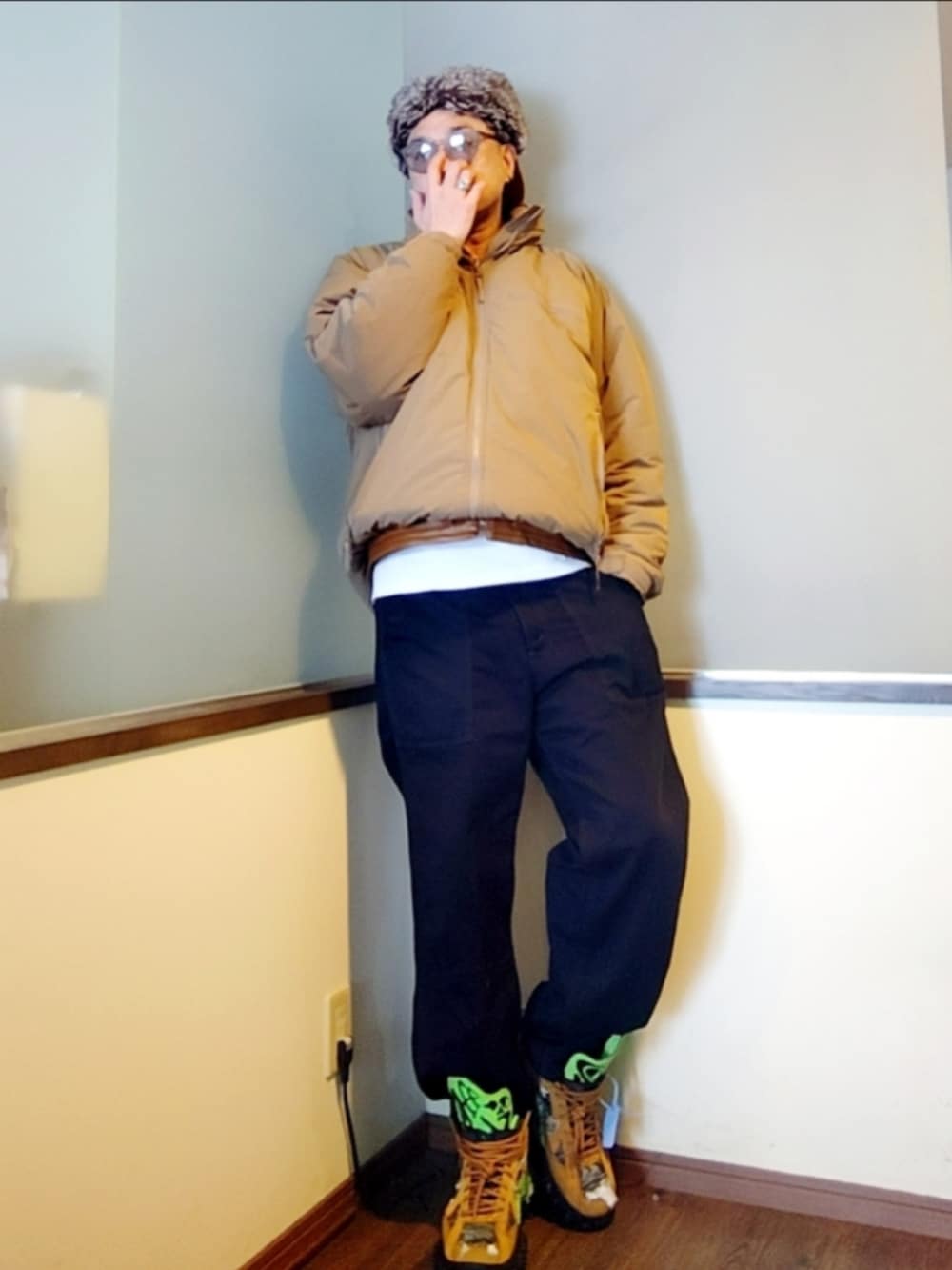 ベージュ系のダウンジャケット/コート、ホワイト系のTシャツ/カットソー、ブラウン系のダウンベストを着用したメンズの冬コーディネートの2枚目の写真