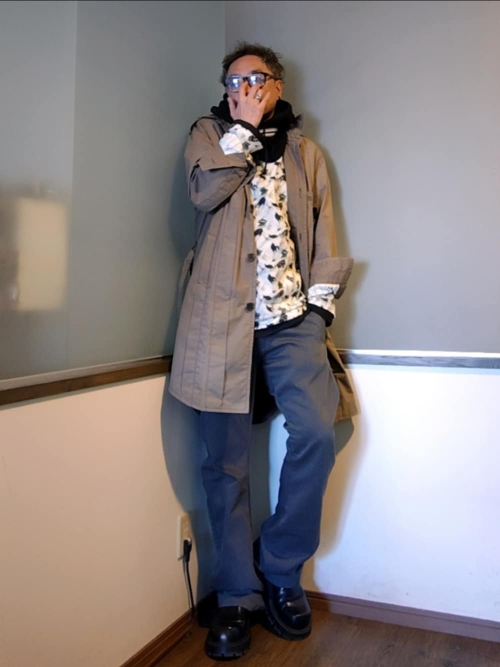 グリーン系のトレンチコート、ホワイト系のシャツ/ブラウス、グレー系のチノパンツを着用したメンズの秋コーディネートの3枚目の写真