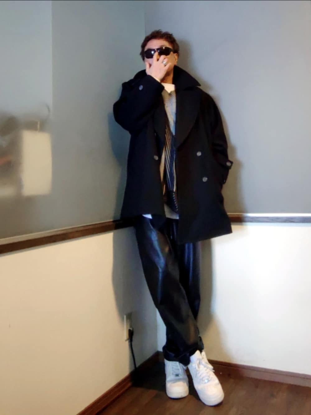 ホワイト系のTシャツ/カットソー、ブラック系のピーコート、ブラック系のパンツを着用したメンズの春コーディネートの4枚目の写真