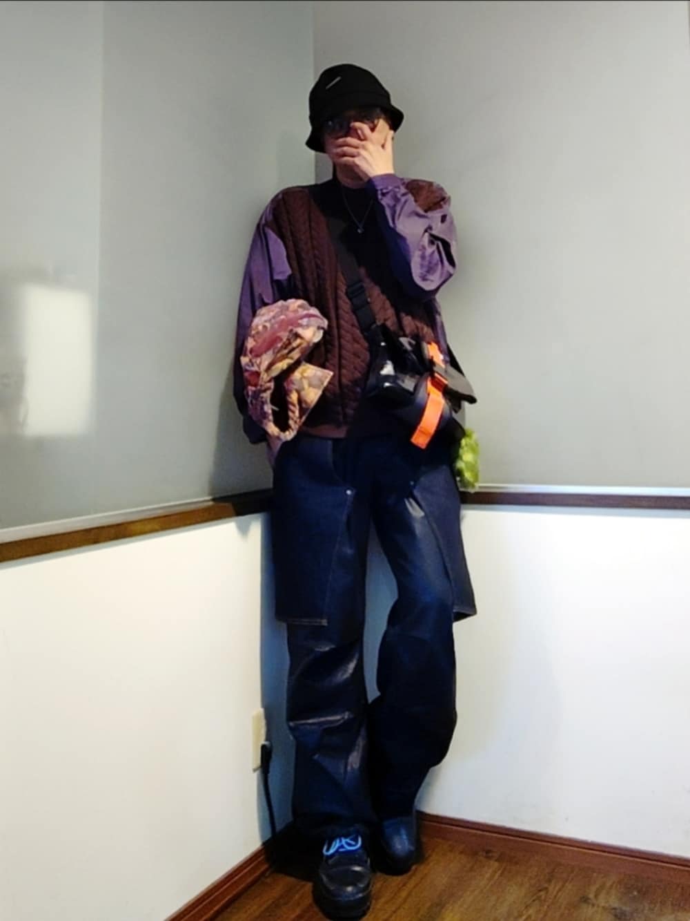 ピンク系のブルゾン、パープル系のニット/セーター、ブルー系のデニムパンツを着用したメンズの秋コーディネートの3枚目の写真