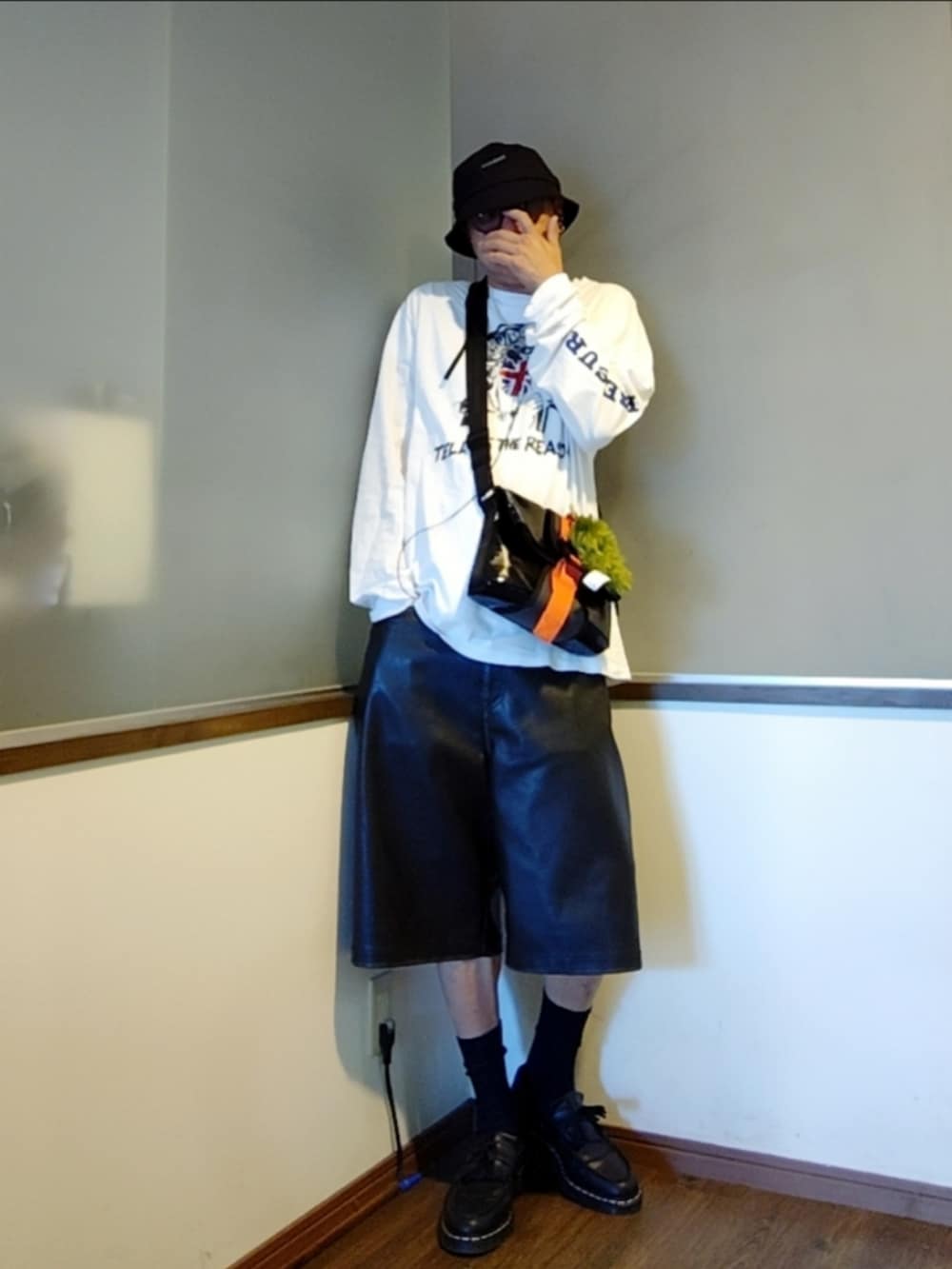 ホワイト系のTシャツ/カットソー、ブラック系のショルダーバッグ、ブラック系のその他パンツを着用したメンズの秋コーディネートの2枚目の写真