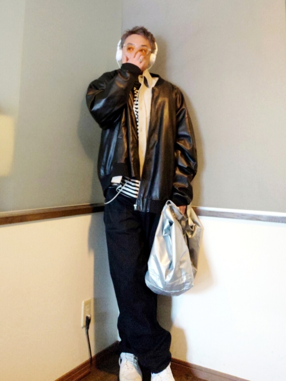 ブラック系のチノパンツ、ホワイト系のスニーカー、シルバー系のトートバッグを着用したメンズの春コーディネートの3枚目の写真