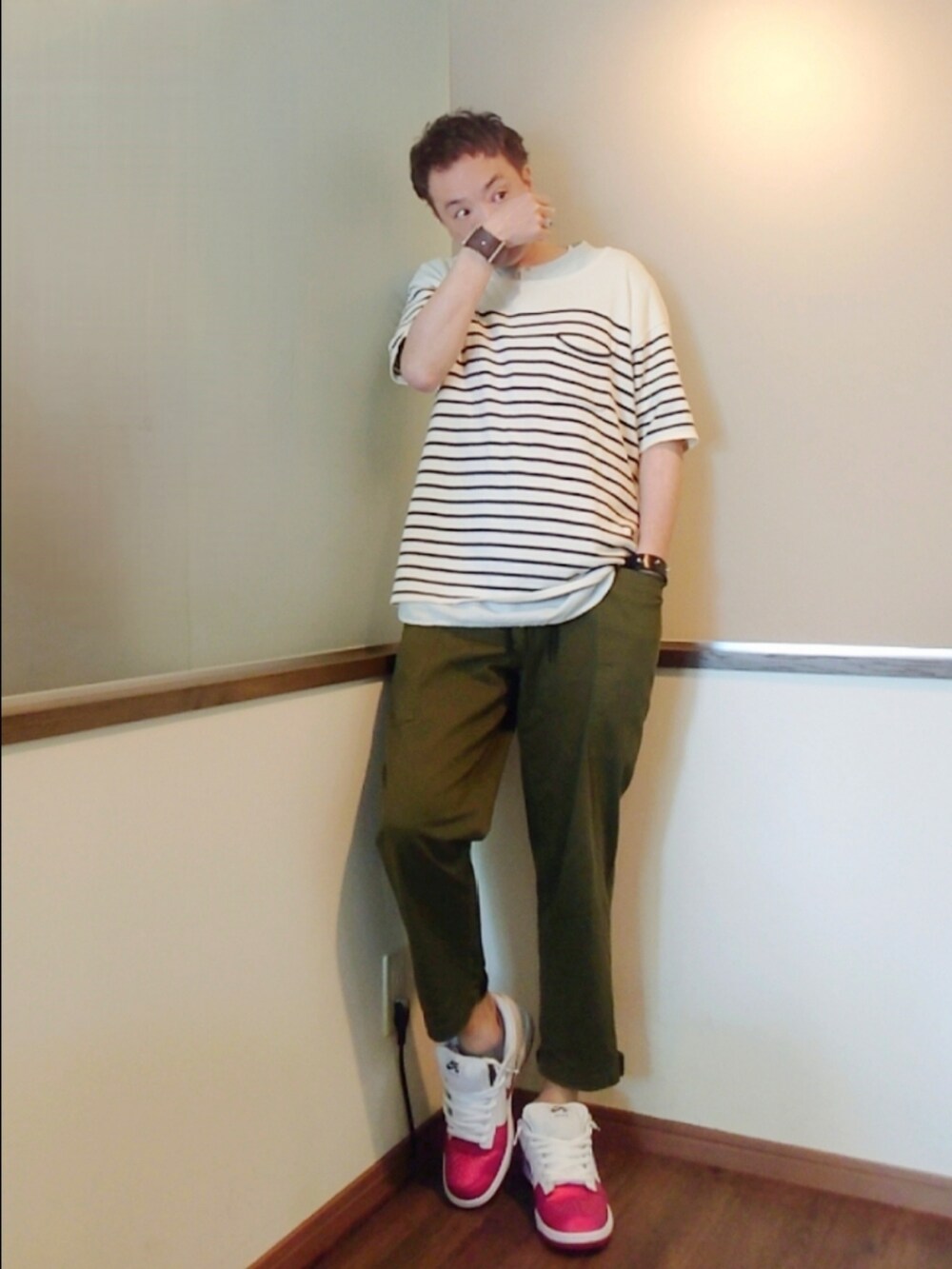 ホワイト系のニット/セーター、グリーン系のチノパンツ、ホワイト系のスニーカーを着用したメンズの春コーディネートの2枚目の写真