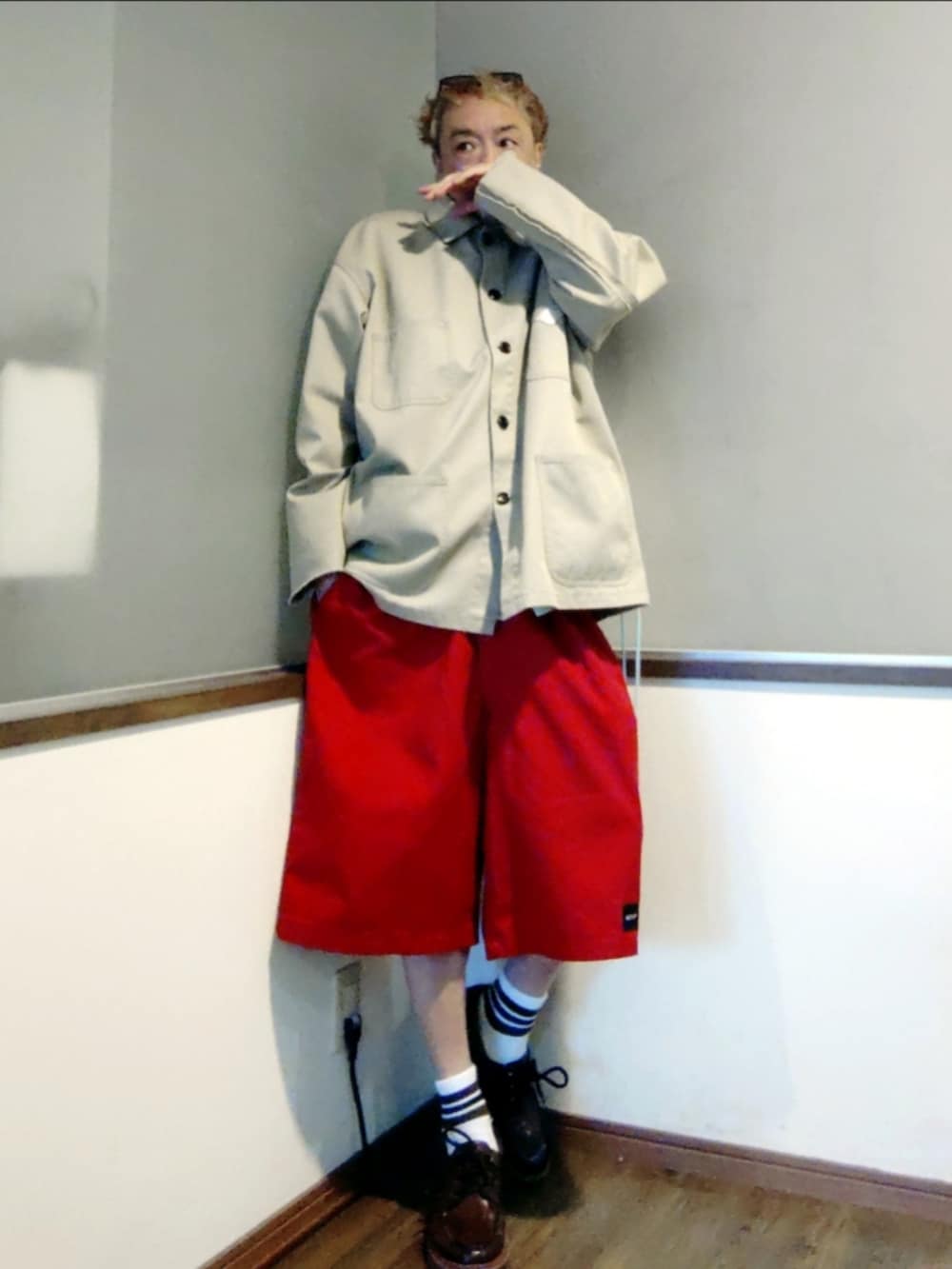 ベージュ系のカバーオール、レッド系のチノパンツ、ブラウン系のモカシン/デッキシューズを着用したメンズの春コーディネートの3枚目の写真