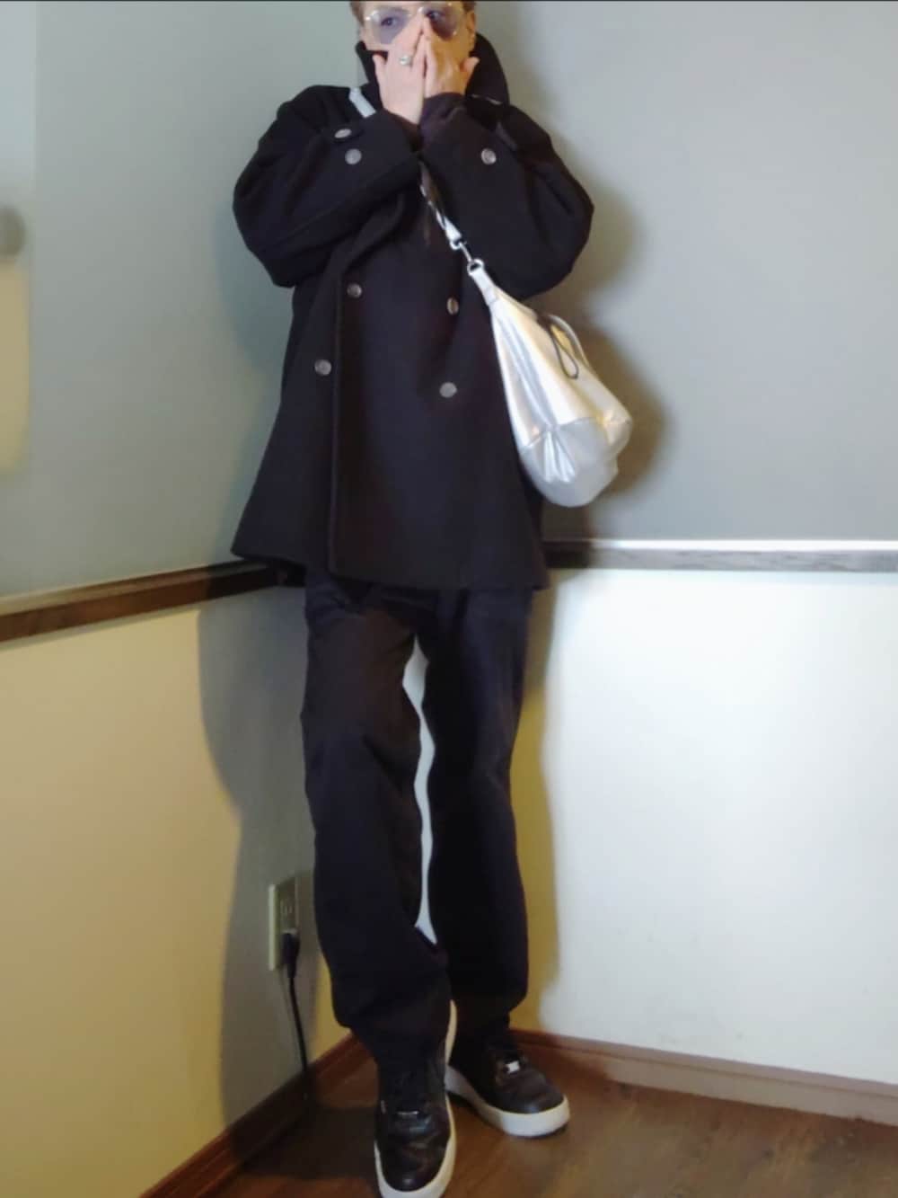 ブラック系のポロシャツ、ブラック系のブルゾン、ブラック系のピーコートを着用したメンズの冬コーディネートの3枚目の写真