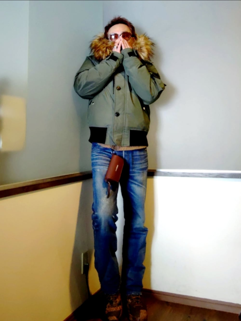 グリーン系のミリタリージャケット、ブルー系のデニムパンツ、ブラウン系のブーツを着用したメンズの冬コーディネートの2枚目の写真