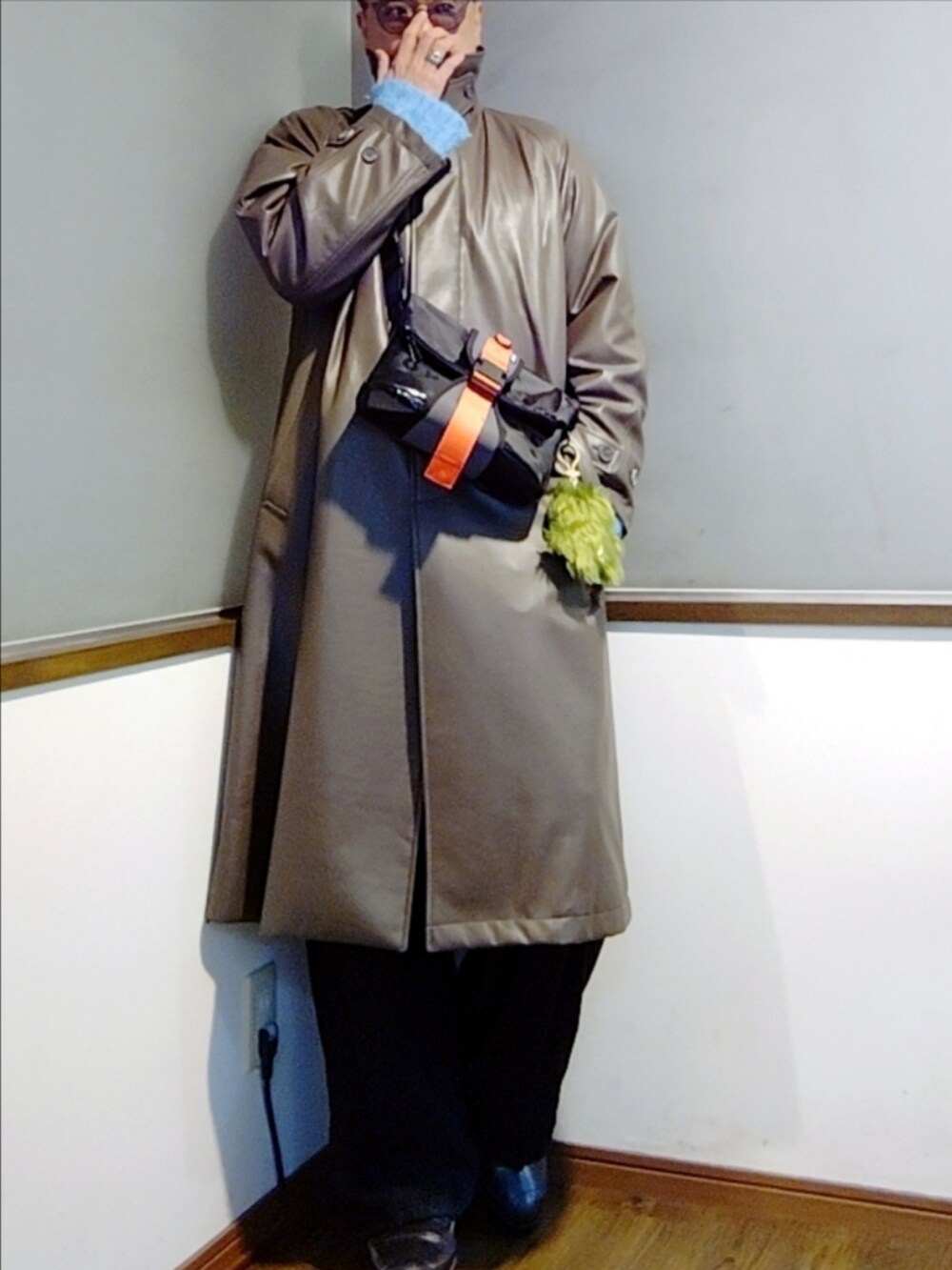 ブラック系のスウェットパンツ、ブルー系のニット/セーター、ブラック系のショルダーバッグを着用したメンズの冬コーディネートの3枚目の写真