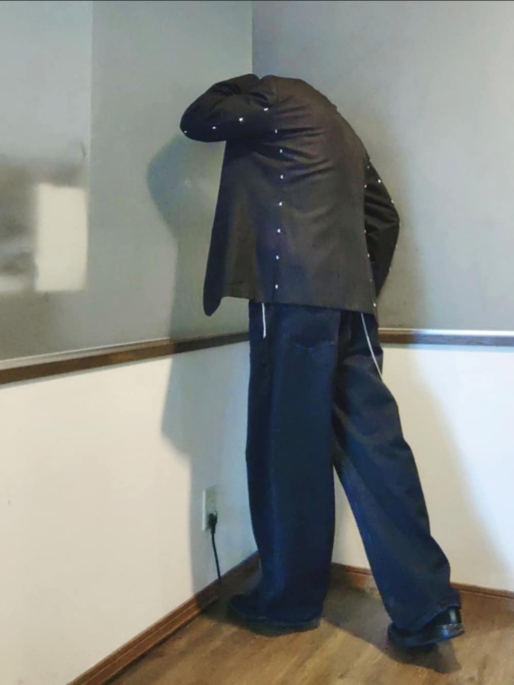 ブラック系のデニムパンツ、ブラック系のスニーカー、グレー系のテーラードジャケットを着用したメンズの春コーディネートの2枚目の写真
