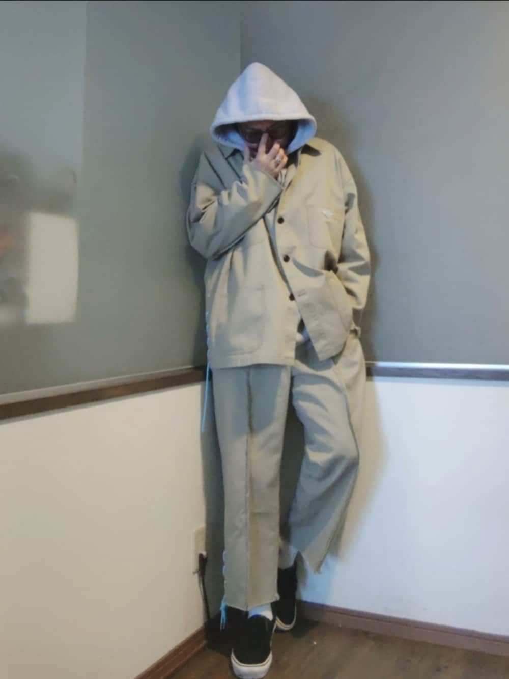 ベージュ系のカバーオール、グレー系のパーカー、ベージュ系のその他パンツを着用したメンズの春コーディネートの2枚目の写真