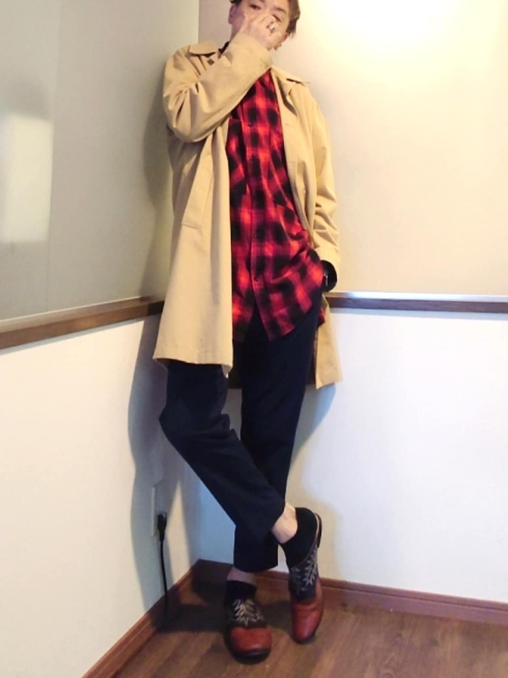 ベージュ系のステンカラーコート、レッド系のシャツ/ブラウス、ブルー系のスラックスを着用したメンズの春コーディネートの2枚目の写真