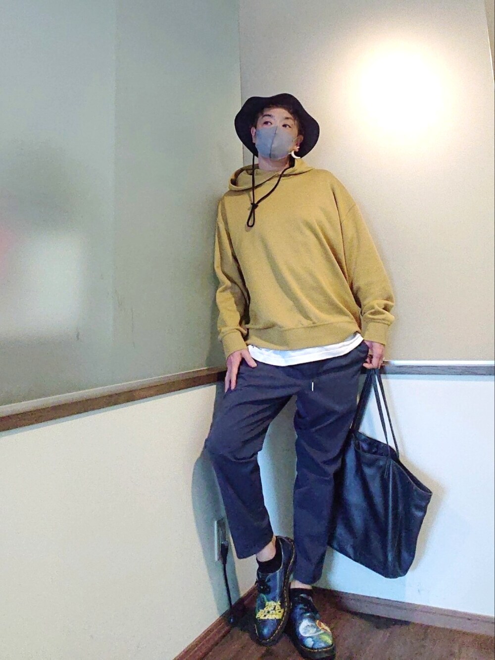 イエロー系のパーカー、グレー系のその他パンツ、ブルー系のシューズを着用したメンズの春コーディネートの3枚目の写真