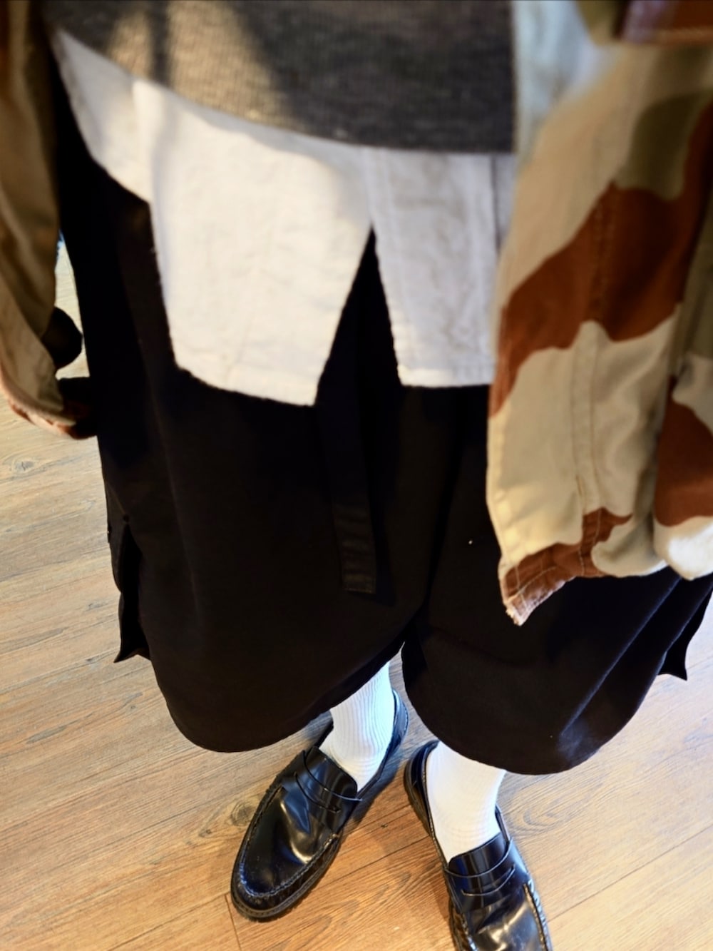 ベージュ系のミリタリージャケット、グレー系のスウェット、ブラック系のカーゴパンツを着用したメンズの秋コーディネートの3枚目の写真