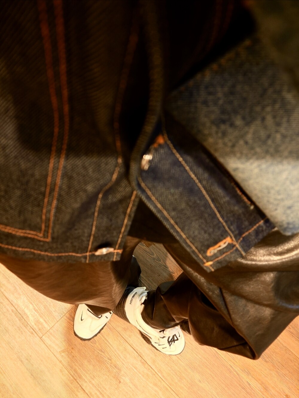 ブルー系のデニムジャケット、ブラック系のダウンジャケット/コート、ブルー系のショルダーバッグを着用したメンズの冬コーディネートの4枚目の写真